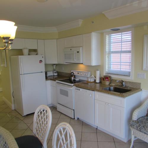 a kitchen with a white refrigerator and a sink at Edison Beach House in Fort Myers Beach