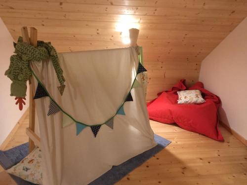 a room with a bed and a curtain in a attic at Chalupa Rozmarýna in Mařenice