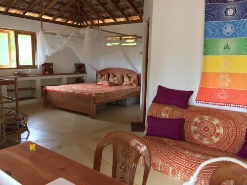 a bedroom with a bed and a table in a room at Sunshine Cafe in Tangalle