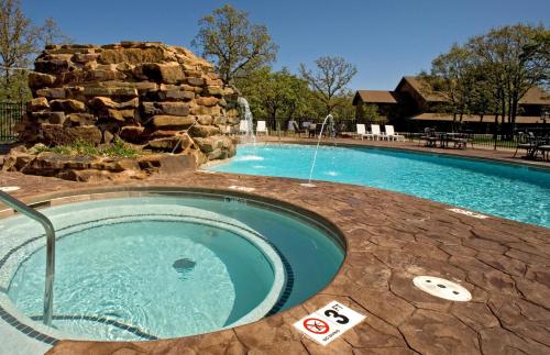 a large swimming pool with a water fountain at POSTOAK Lodge and Retreat in Tulsa