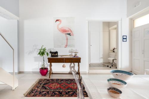 Suite 18, casa di charme in Ortigia في سيراكوزا: غرفة معيشة مع طاولة وطائر على الحائط