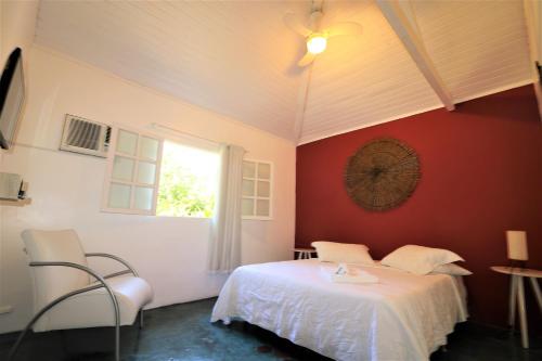 a bedroom with a white bed and a window at Atobá Villas in Paraty