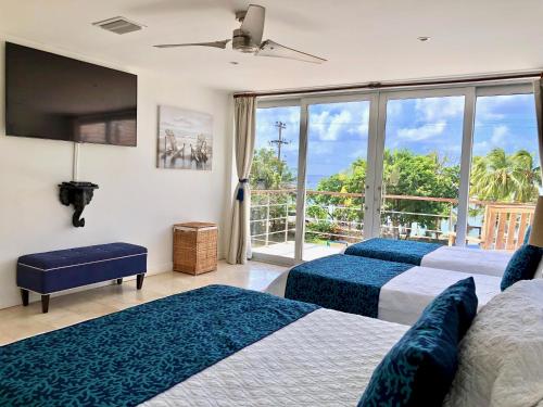 a bedroom with three beds and a balcony at Alquiler de Casa Completa-Casa Iguana Del Mar in San Andrés