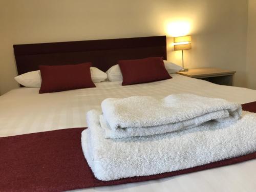 a bed with white towels sitting on top of it at Hinsley Hall in Leeds