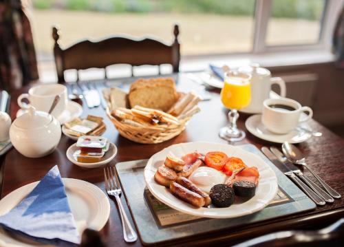 a table with a plate of breakfast food on it at The Waterfront House Country Home in Oughterard