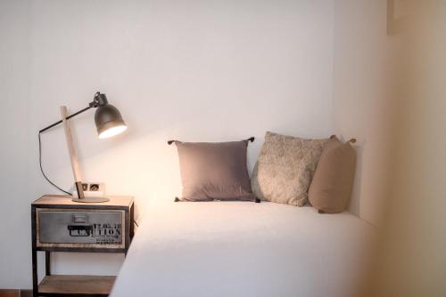 a bed with two pillows sitting next to a lamp at Chambres d'Hôtes Le Pignié in Lescure-dʼAlbigeois
