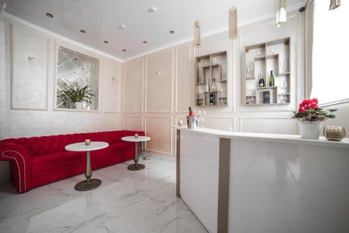 Sergeev Hotel في نيكولايف: غرفة معيشة مع أريكة حمراء ومقعد احمر