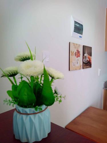 a blue vase with white flowers on a table at Amani Grand Resort Residences near Mactan Cebu Intl Airport in Mactan