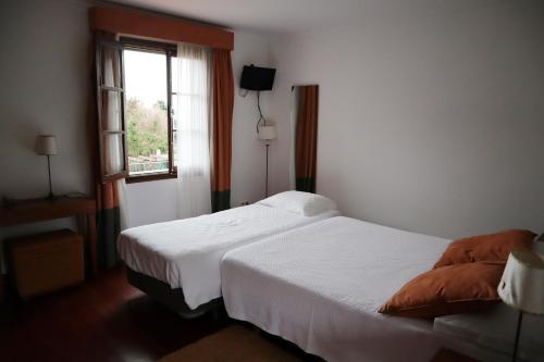 a bedroom with a white bed and a window at Casa D'Avo Beatriz in Gaula
