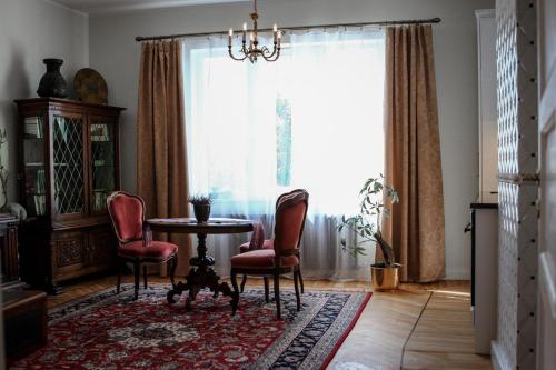 een eetkamer met een tafel en stoelen en een raam bij Posti Apartment in Haapsalu