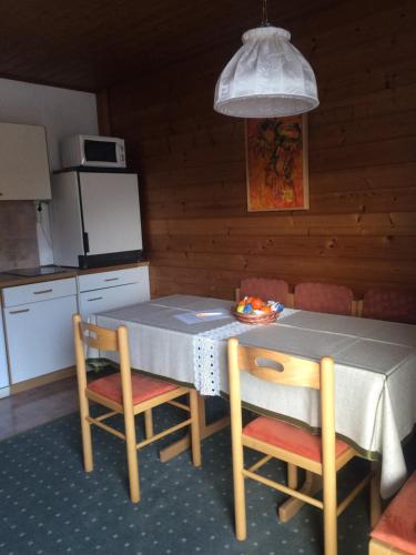 a kitchen with a table and two chairs and a kitchen with a refrigerator at Ferienwohnung Salchegger in Flachau