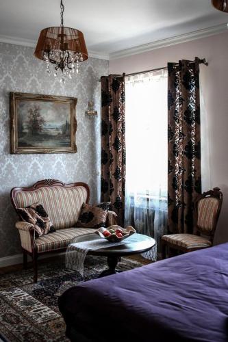 a bedroom with a bed and a couch and a table at Posti Apartment in Haapsalu