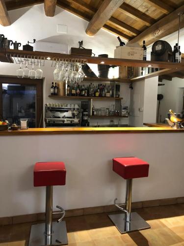 a bar with two red stools in a kitchen at Resort Fonte Vulci in Canino
