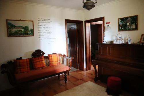 a living room with a bench and a piano at Casa D'Avo Beatriz in Gaula