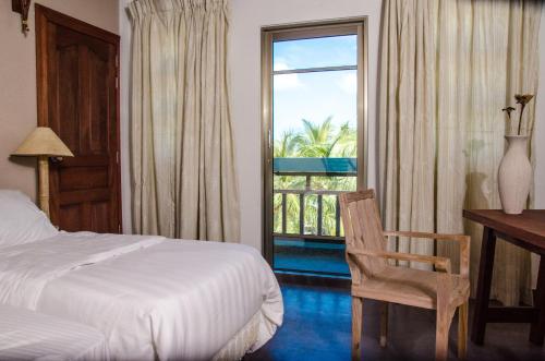 1 dormitorio con cama, escritorio y ventana en Cerulean View Residence, en Hanimaadhoo