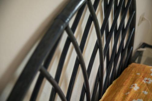 a black metal headboard of a bed with a wooden table at Case Canino in Favignana