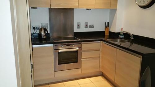 uma cozinha com um fogão e um lavatório em Oxford Apartment Central - Jericho Riverfront--Free parking -2 bedrooms- 2 bathrooms - Easy walk to Bus and Rail station em Oxford