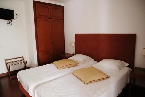 a bedroom with a bed with two pillows on it at Casa D'Avo Beatriz in Gaula