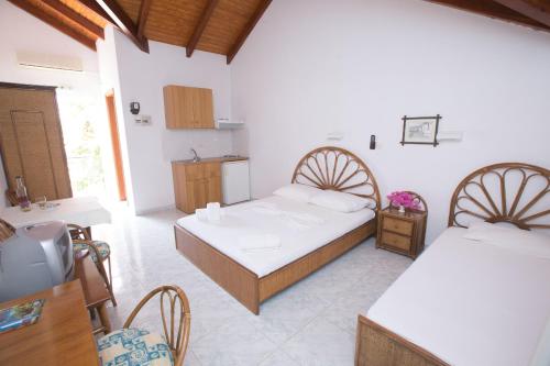 Habitación con 2 camas, mesa y cocina. en Marina Studios II, en Argostoli
