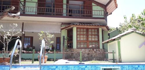 a house with a swimming pool in front of a building at Casarão Villa al Mare in Ubatuba