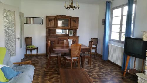 une salle à manger avec une table et des chaises et une télévision dans l'établissement Chez Marie, à Saint-Martin-le-Redon