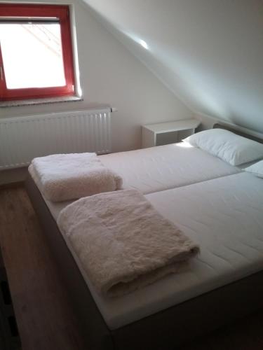 a bedroom with two beds with white sheets and a window at Hudinja 111 in Vitanje