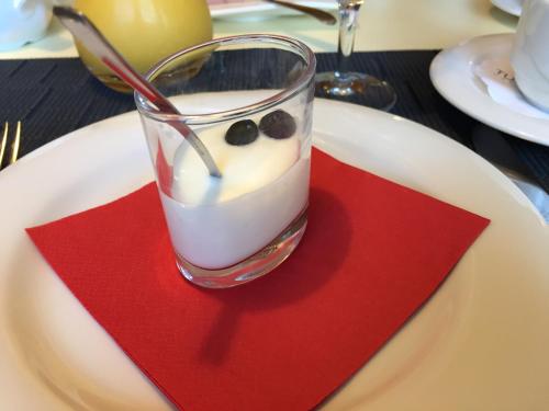 a glass of yogurt on a plate with a red napkin at Landgasthaus Bären in Grub