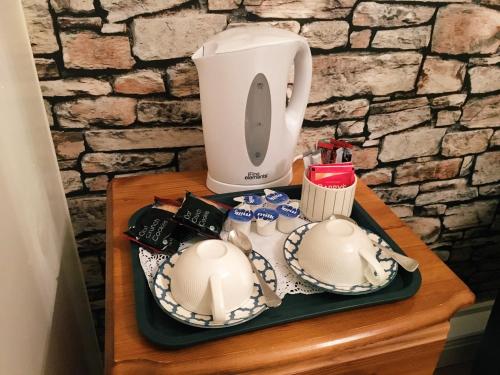 a coffee maker and dishes on a table at Abbeyvilla Guesthouse Room Only in Adare