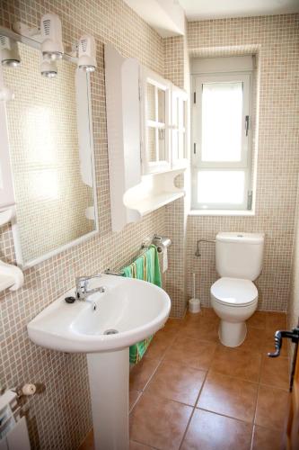 a bathroom with a white sink and a toilet at Casa Buenavista Cazorla in Cazorla