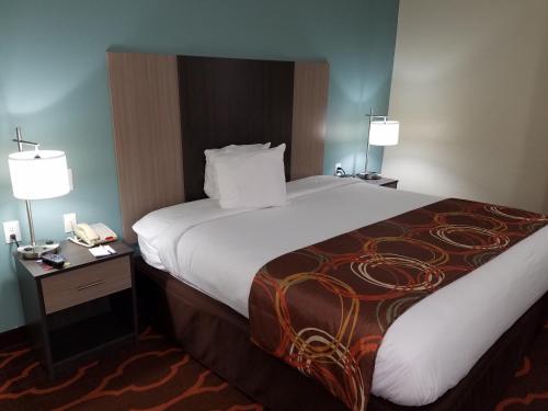 a hotel room with a large bed and two lamps at Baymont by Wyndham Grovetown Augusta in Augusta