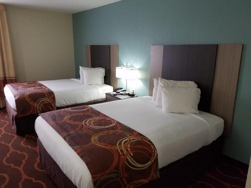 a hotel room with two beds and a lamp at Baymont by Wyndham Grovetown Augusta in Augusta