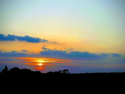 a sunset with the sun setting in the sky at Polborder Holidays Looe Country Park in Looe