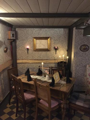 uma sala de jantar com uma mesa de madeira e cadeiras em Himmel & Hölle em Quedlinburg