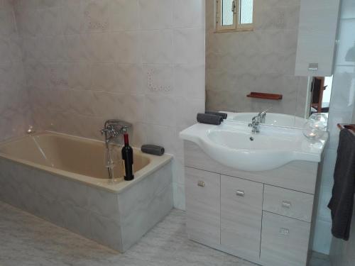 a bathroom with a sink and a tub and a sink and a mirror at casa vacanza laguna in Càbras