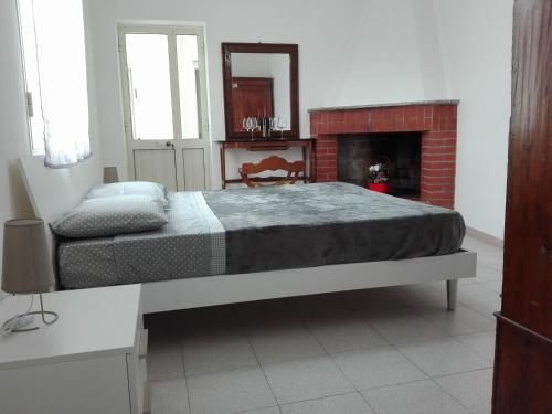 a bedroom with a large bed and a fireplace at casa vacanza laguna in Càbras