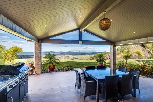 une cuisine extérieure avec une table et des chaises sur une terrasse dans l'établissement Napier B&B - Tequila Sunrise, à Eskdale