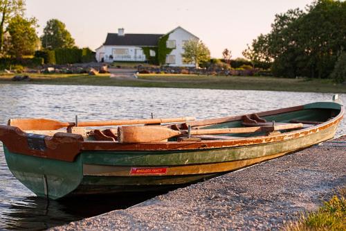 a wooden boat sitting on the shore of a lake at The Waterfront House Country Home in Oughterard