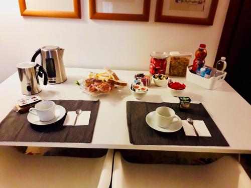 d'une table avec deux plateaux de service avec des tasses et des soucoupes dans l'établissement B&B Mo Va Là, à Budrio