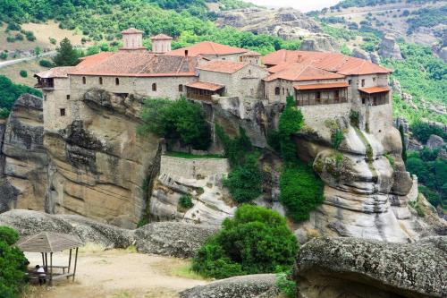 a building on the side of a mountain at Thalia Rooms in Kalabaka
