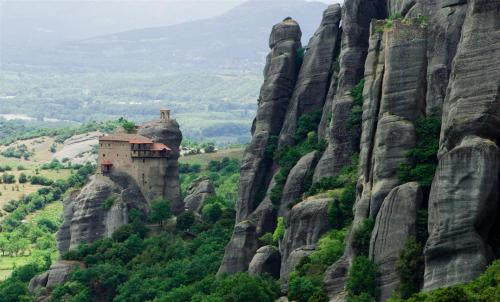 a building on the side of a mountain at Thalia Rooms in Kalabaka