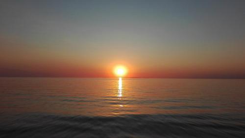 a sunset over the ocean with the sun setting at casa vacanza laguna in Càbras