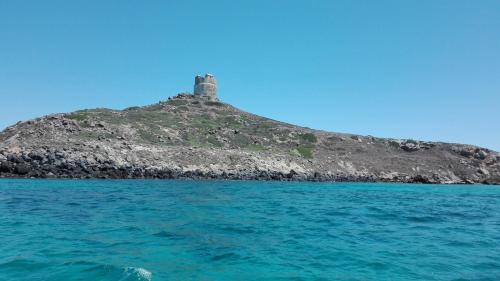 an island in the ocean with a lighthouse on it at casa vacanza laguna in Càbras