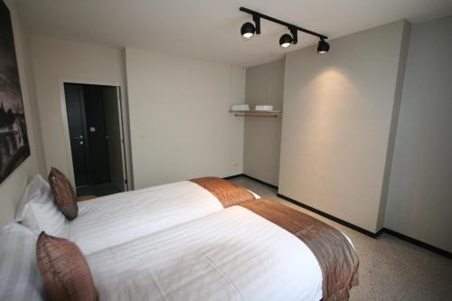 a bedroom with a large white bed in a room at Amosa Liège City Centre Apart Regence 17 in Liège