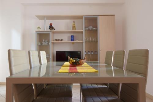 - une table à manger avec des chaises et une corbeille de fruits dans l'établissement Cortile Fichi d'india, à Sciacca