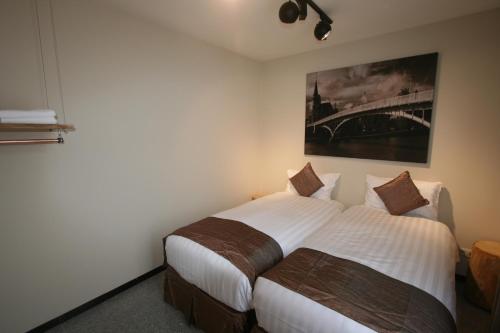 a bedroom with two beds and a painting on the wall at Amosa Liège City Centre Apart Regence 17 in Liège