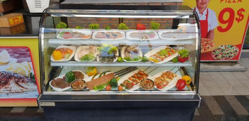 a display case filled with different types of food at Benny's City Hotel in Sihanoukville