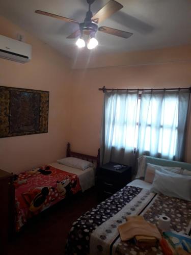 a bedroom with two beds and a ceiling fan at Residencial Shalom in Cafayate