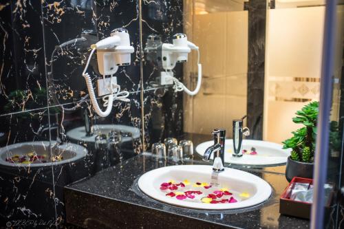 ein Badezimmer mit zwei Waschbecken und Blumen auf der Theke in der Unterkunft Lieber Hotel 2 in Hanoi