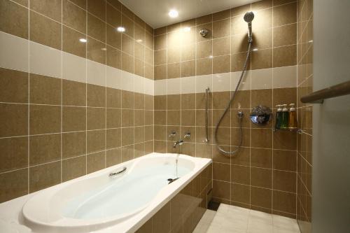 a bathroom with a bath tub and a shower at Kyoto Brighton Hotel in Kyoto