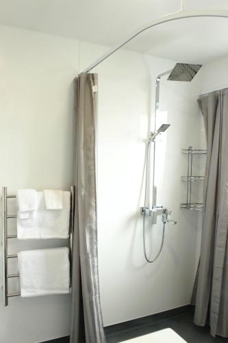 a bathroom with a shower with a mirror and towels at Colonial Motel in Invercargill